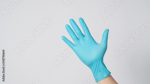 Right hand with blue gloves on white background.
