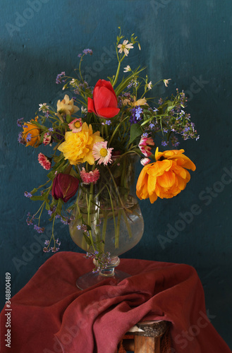 A bouquet of spring flowers on a chair on a dark background