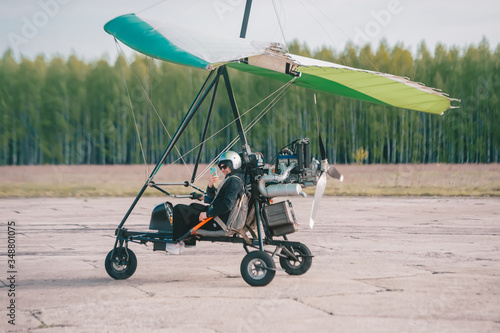 Obraz na płótnie Pilot is using a smart phone and smiling while doing selfie in moto hang-glider w salonie