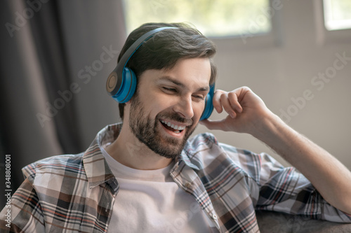 Happy young adult man in headphones smiling. photo