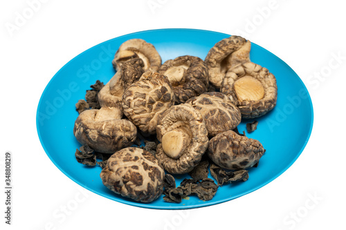 Dried Shiitake Mushroom on blue plate. Isolated on white background