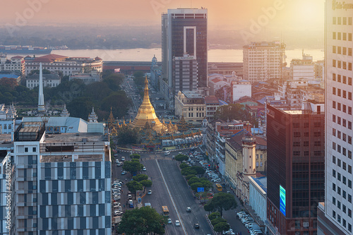 01/22/2020 Yangon, Myanmar (Burma), Aerial shot, view from the drone on the downtovn of Yangon with Shwedagon Pagoda and street traffic at sunset pop colors. Yangon - the ancient capital of Burma photo