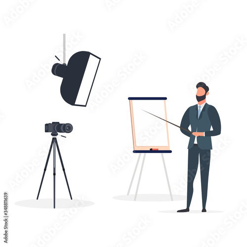 A man in a business suit with a tie is giving a presentation to the camera. The teacher is writing a lesson. The concept of blogging, online training and conferences. Camera on a tripod, softbox. 