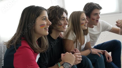 Young people supporting German national team on tv photo