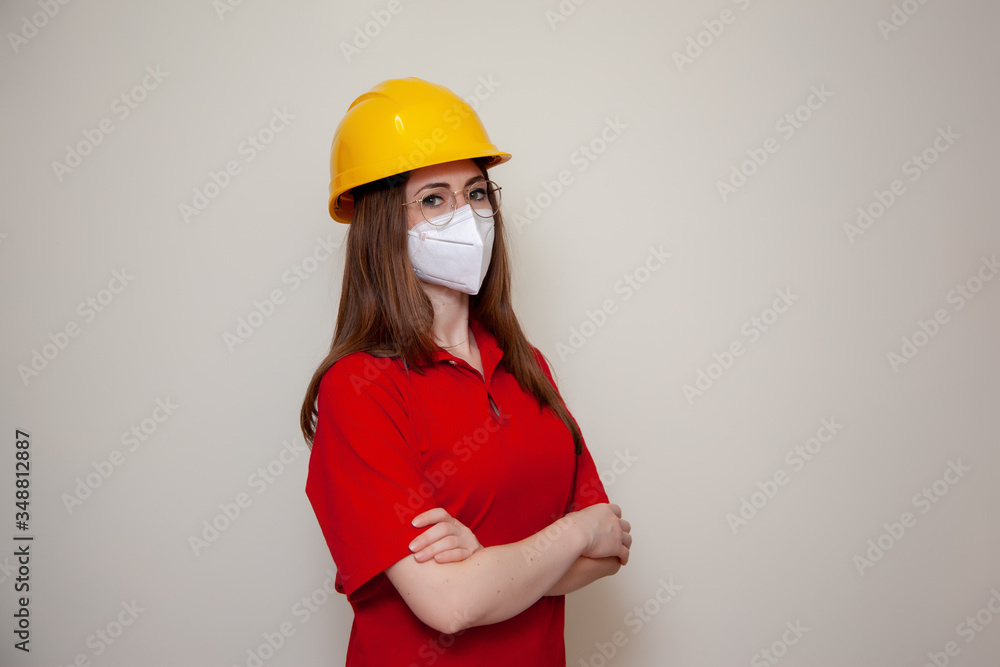 The Worker woman with helmet wears a protective antivirus mask such as coronavirus covid-19 or sars The Worker woman with helmet wears a protective antivirus mask such as coronavirus covid-19 or sars