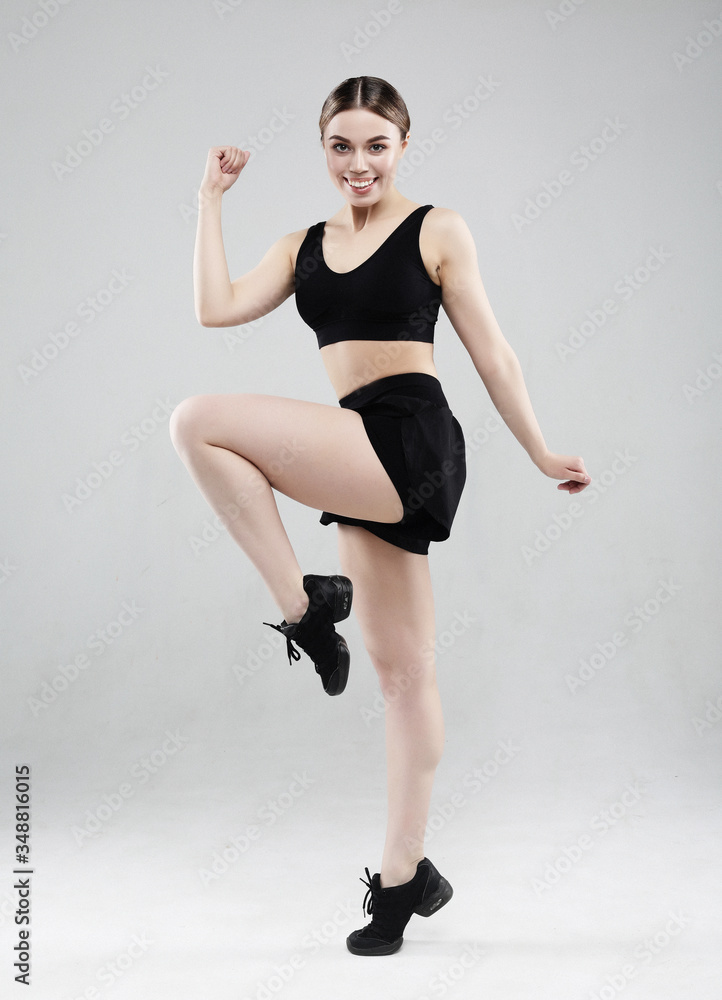 lovely young woman in sportswear jumping on a white background, sport concept