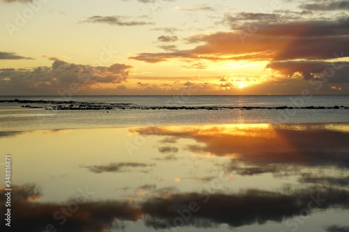 Sunset by the beach and reflection on the water