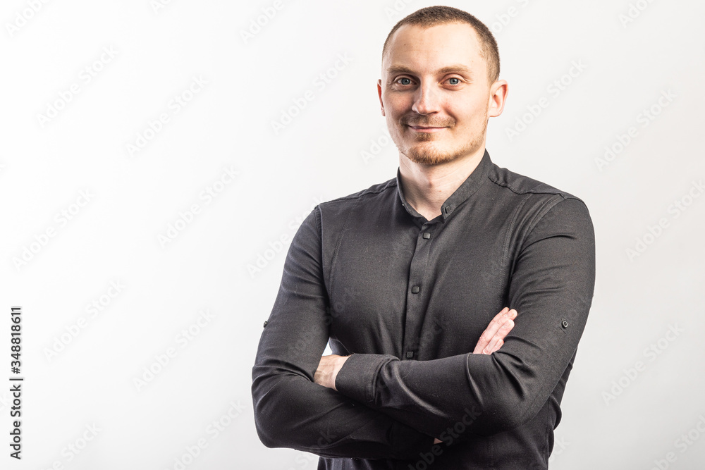 Young smiling man in a black shirt on a light background Young smiling man in a black shirt on a light background