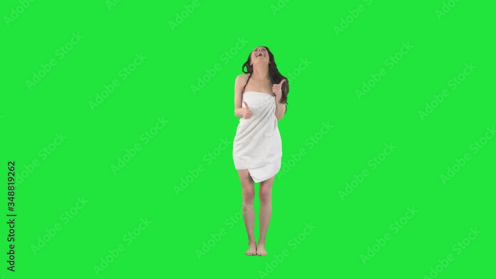 Excited happy young beauty in towel with wet hair showing thumbs up and smiling. Full body pre keyed on green screen chroma key background Excited happy young beauty in towel with wet hair showing thumbs up and smiling. Full body pre keyed on green screen chroma key background