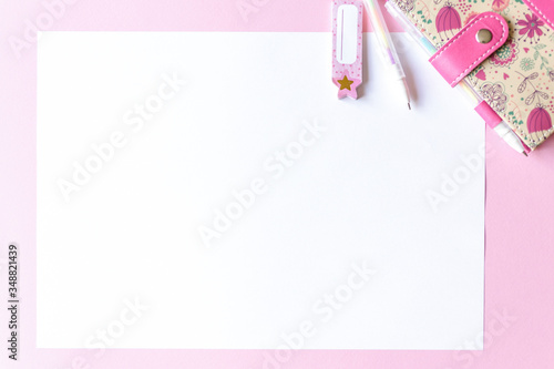 Colorful pink background with party decoration, notebook and free space for text, mock-up. Top view. Learning to draw, making wish list, events or plans. photo