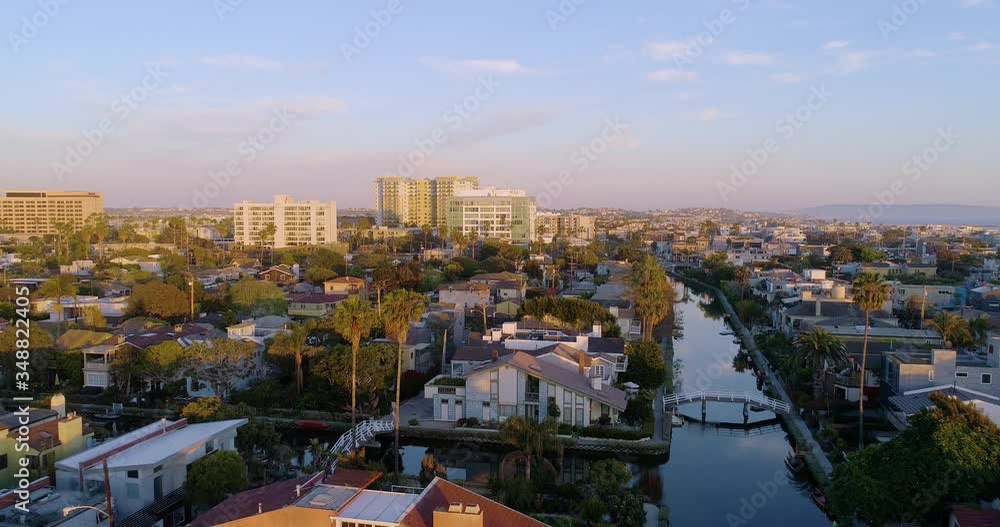 Aerial, reverse, drone shot over a reflecting Venice Canals empty for Covid19, during golden hour, in Los Angeles, California, United states Aerial, reverse, drone shot over a reflecting Venice Canals empty for Covid19, during golden hour, in Los Angeles, California, United states
