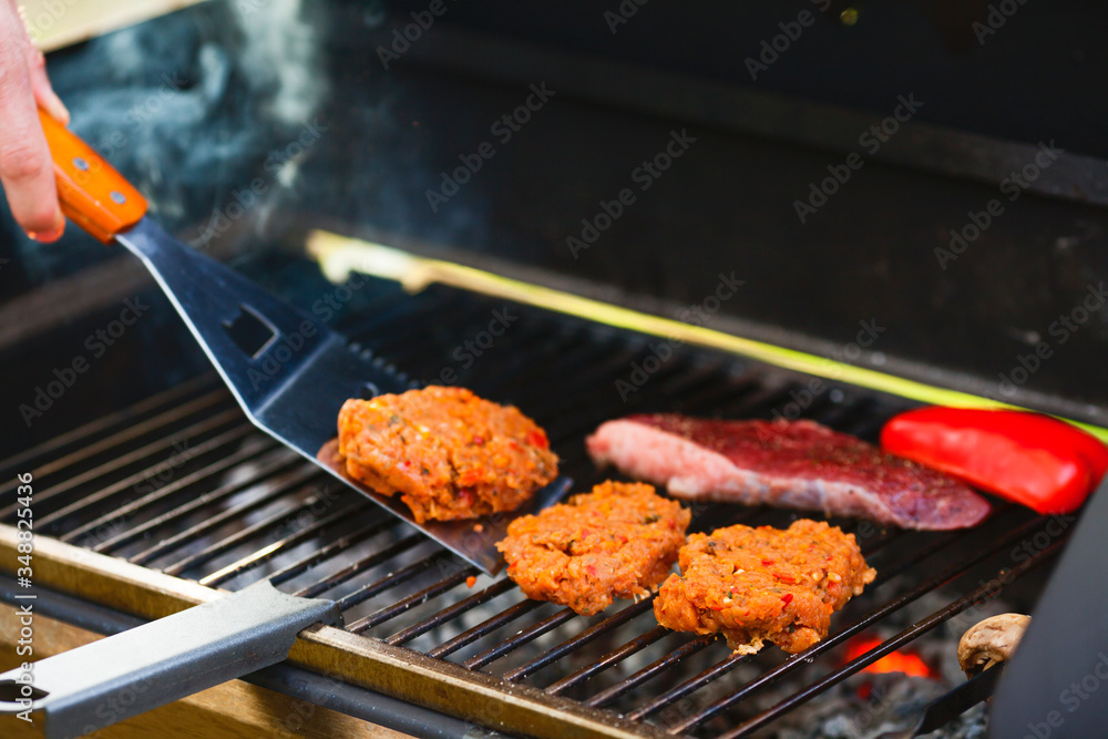 Barbecue and homemade food concept. Steak, red pepper and burger cutlet on grill. 