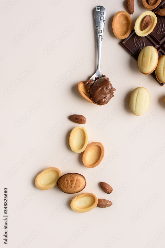 custom made wallpaper toronto digitalA bar of chocolate lies on a light background with almonds, walnuts, nuts with boiled condensed milk. View from above, place for text. Flat lay