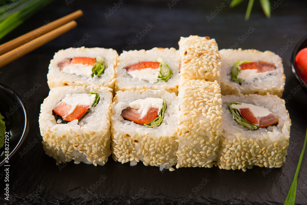 Set of sushi rolls with wasabi and ginger on a black background. Japanese oriental cuisine Set of sushi rolls with wasabi and ginger on a black background. Japanese oriental cuisine