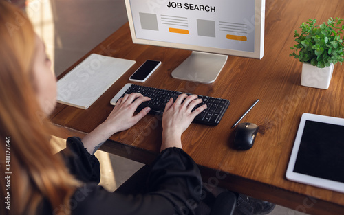 Woman looking for a job during worldwide crisis. Find a job online. Business, internet and networking concept. Woman looks through vacancies and sends resumes, needs to earn. Modern digital search bar