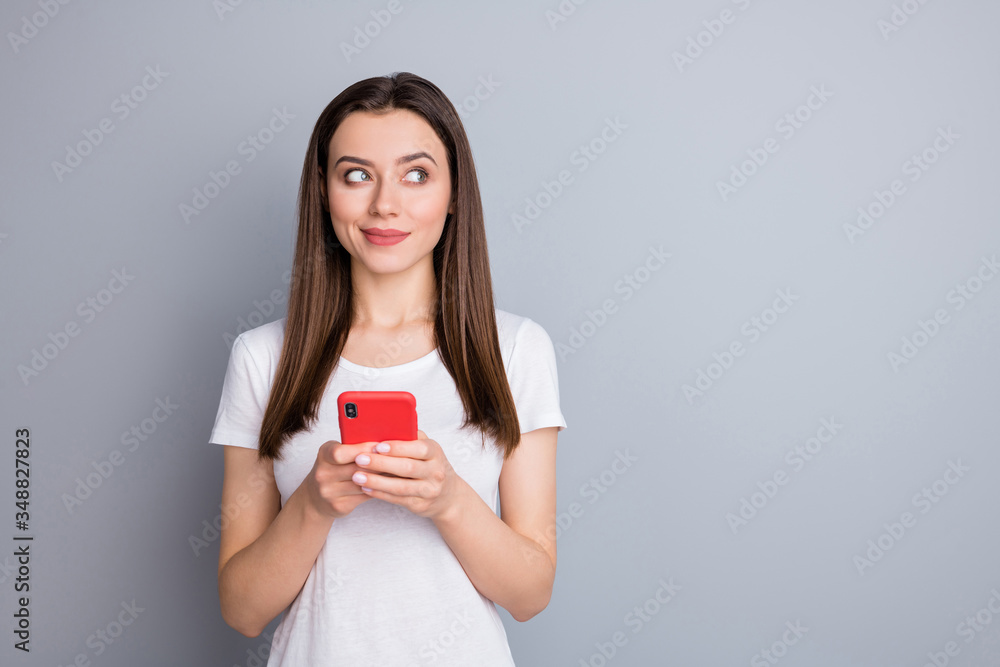 Portrait of curious interested dream dreamy girl look copyspace think thoughts use smartphone decide social network post wear style stylish outfit isolated over gray color background Portrait of curious interested dream dreamy girl look copyspace think thoughts use smartphone decide social network post wear style stylish outfit isolated over gray color background