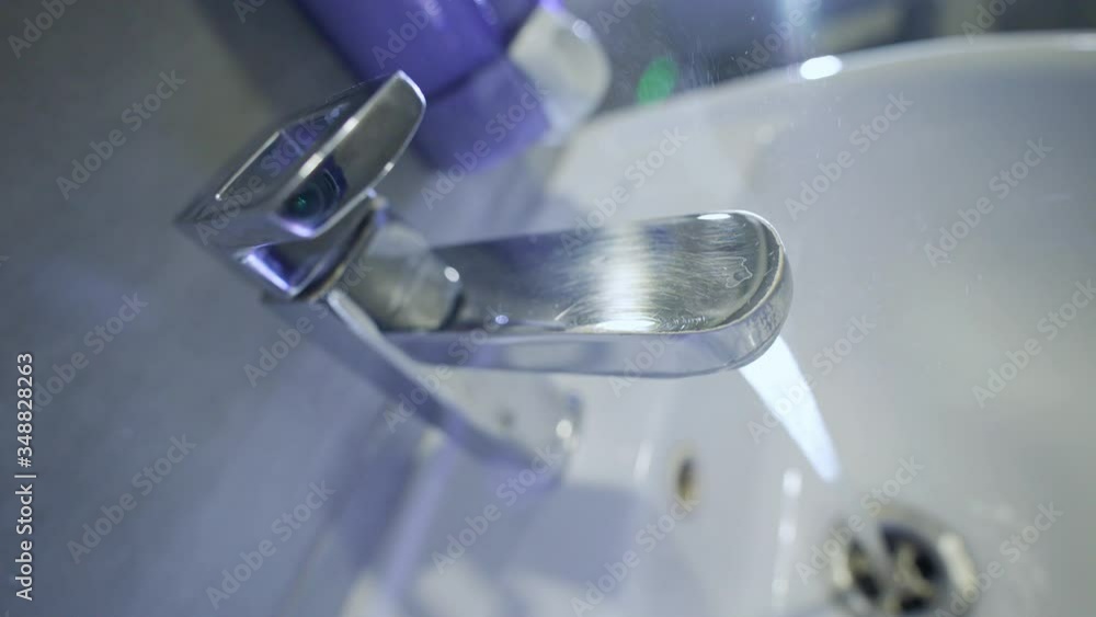 Steam from hot water in the sink. Hot tap water. Warm water flows from the tap in the bathroom. Prevention of a coronavirus pandemic by washing hands with soap. Water jet. Hand hygiene. Steam from hot water in the sink. Hot tap water. Warm water flows from the tap in the bathroom. Prevention of a coronavirus pandemic by washing hands with soap. Water jet. Hand hygiene.