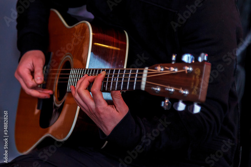 Hands holding a guitar. Make hands while playing guitar in recording Studio. Concept of learning to play the guitar