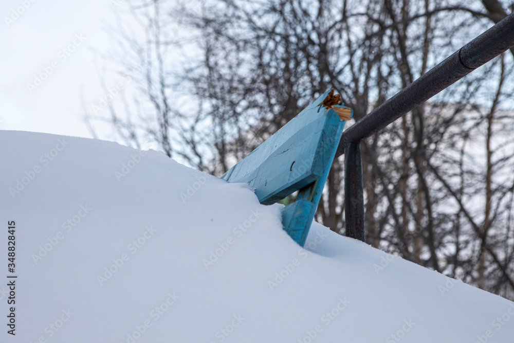the edge of the bench sticking out of the snow. A huge snowdrift in the far North the edge of the bench sticking out of the snow. A huge snowdrift in the far North