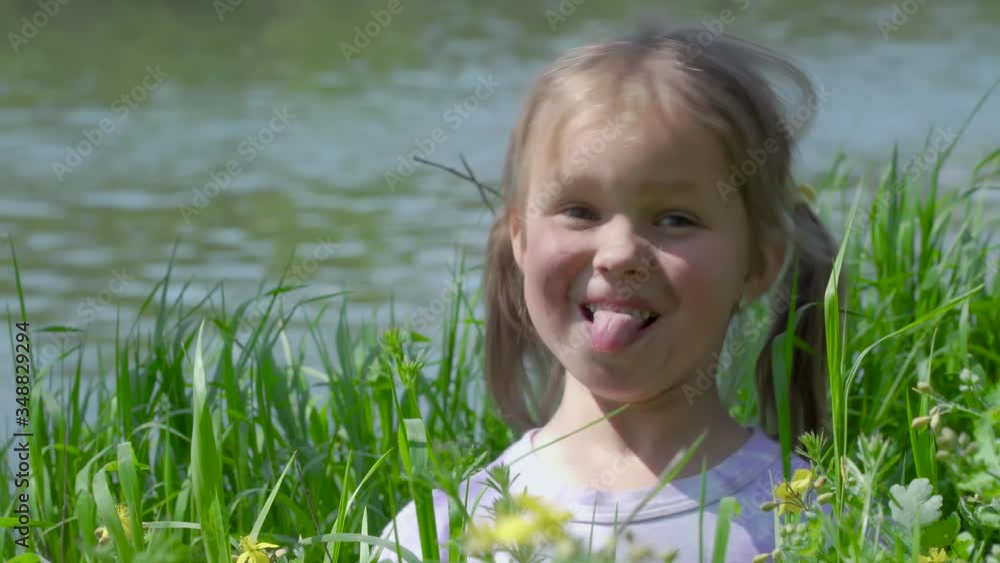 Portrait of a smiling little girl. Funny baby in tall grass. Tiny kid have fun, enjoy nature outdoors. 4K Portrait of a smiling little girl. Funny baby in tall grass. Tiny kid have fun, enjoy nature outdoors. 4K