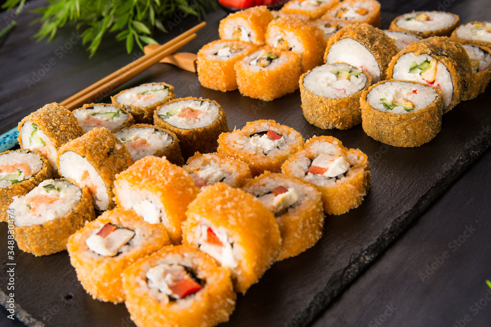 Set of fried sushi rolls with wasabi and ginger on a black background. Japanese oriental cuisine Set of fried sushi rolls with wasabi and ginger on a black background. Japanese oriental cuisine