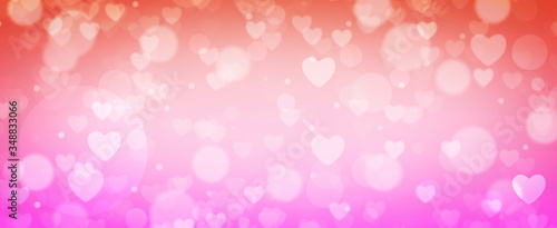 Glowing soft orange and pink bokeh background. Spring concept. Blurred bokeh circles and hearth shapes.