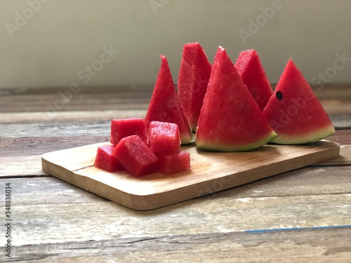 Fresh Watermelon on wood plank,sliced with triangle like christmas tree,dimly light,selective focus.Fruit for summer time.