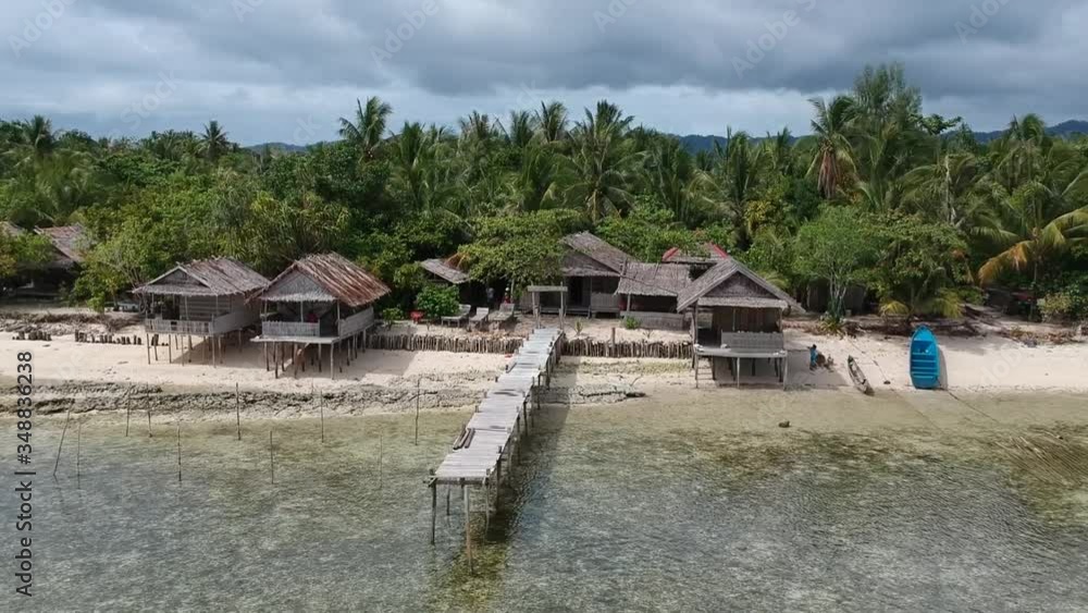 Drone, Raja Ampat wooden huts on the beach with wooden jetty Drone, Raja Ampat wooden huts on the beach with wooden jetty