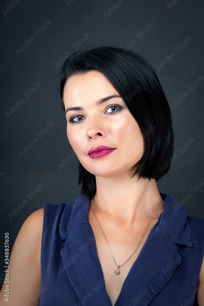 Close up of a beautiful young woman with a golden necklace on a grey background Close up of a beautiful young woman with a golden necklace on a grey background
