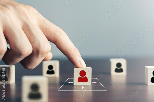 Social distance And expanding human resources concept,Man use their fingers to touch black human symbols on a wooden block. People practice social distancing to protect from  coronavirus or (COVID-19)