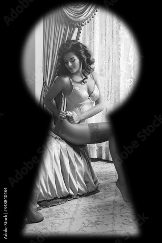 Watching through the keyhole on woman wearing lingerie