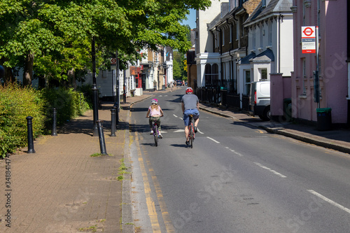 Wallpaper Mural Father and daughter cycle on the bikes in a sunny spring day on the road,  both are in the helmets.The photo is taken from the back. Torontodigital.ca