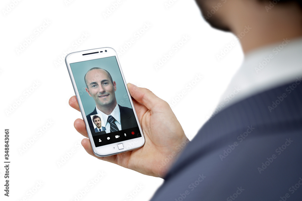 Businessman getting a video call with another man in his mobile phone. Business video conference through smartphone. White background. Businessman getting a video call with another man in his mobile phone. Business video conference through smartphone. White background.