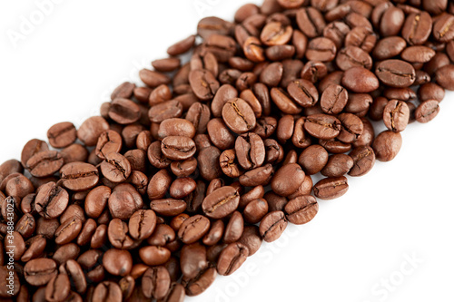 Roasted coffee beans on a white background. The texture of the coffee. An invigorating drink. © stas_malyarevsky