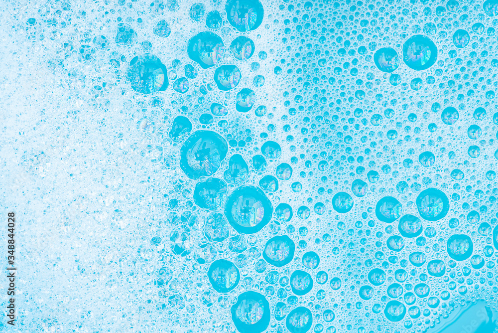 Close-up White Foam with bubbles on surface of water, washing powder ...