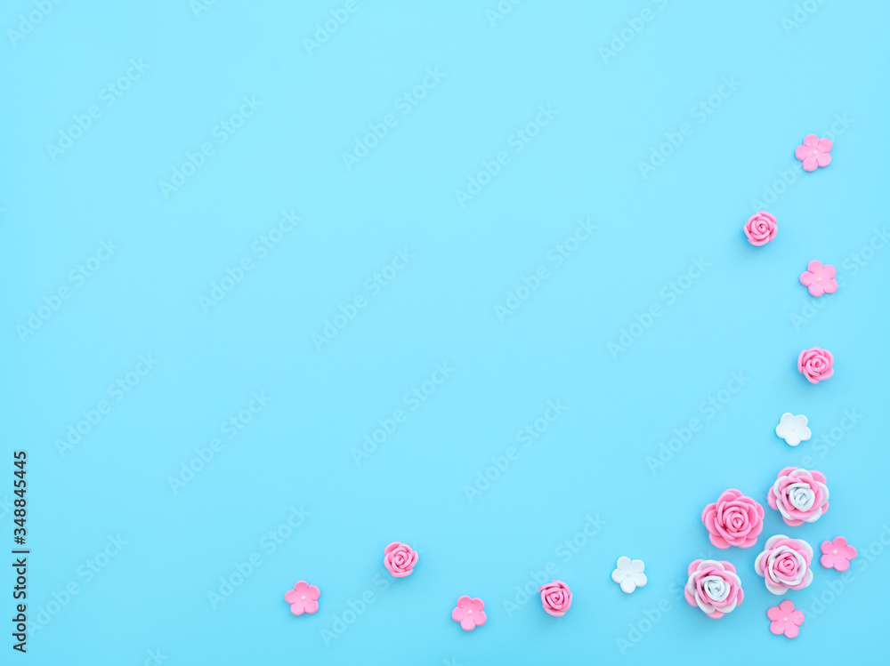 Pink and white flowers made of foamiran on blue background with beads. Mother day, Valentine day, Wedding, Birthday concept. Greeting or invitation card. Flat lay with copy space.