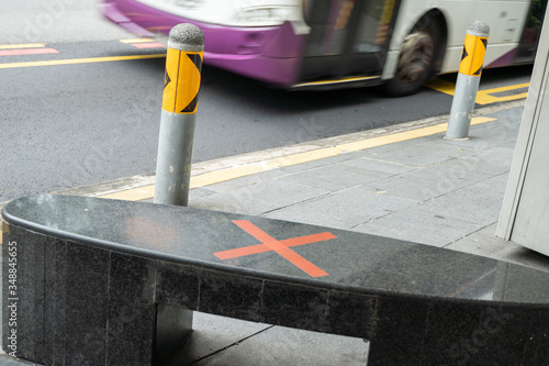 Photography Cross label on a bus stop seat in Singapore during Covid 19