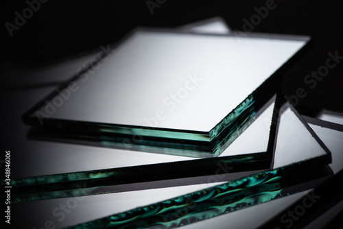 close up view of mirror pieces in stack on black background