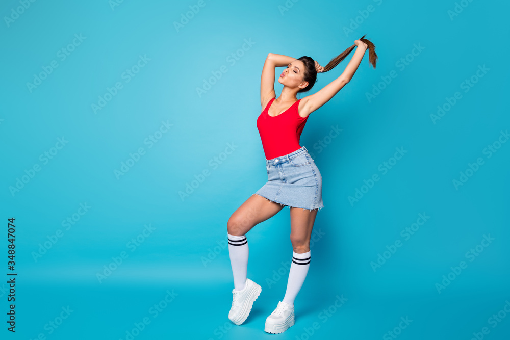 Haircare lotion advertise concept. Full length photo girl hold hand make hairdo 14-february date send air kiss copyspace wear casual red legs singlet jeans white isolated blue color background Haircare lotion advertise concept. Full length photo girl hold hand make hairdo 14-february date send air kiss copyspace wear casual red legs singlet jeans white isolated blue color background