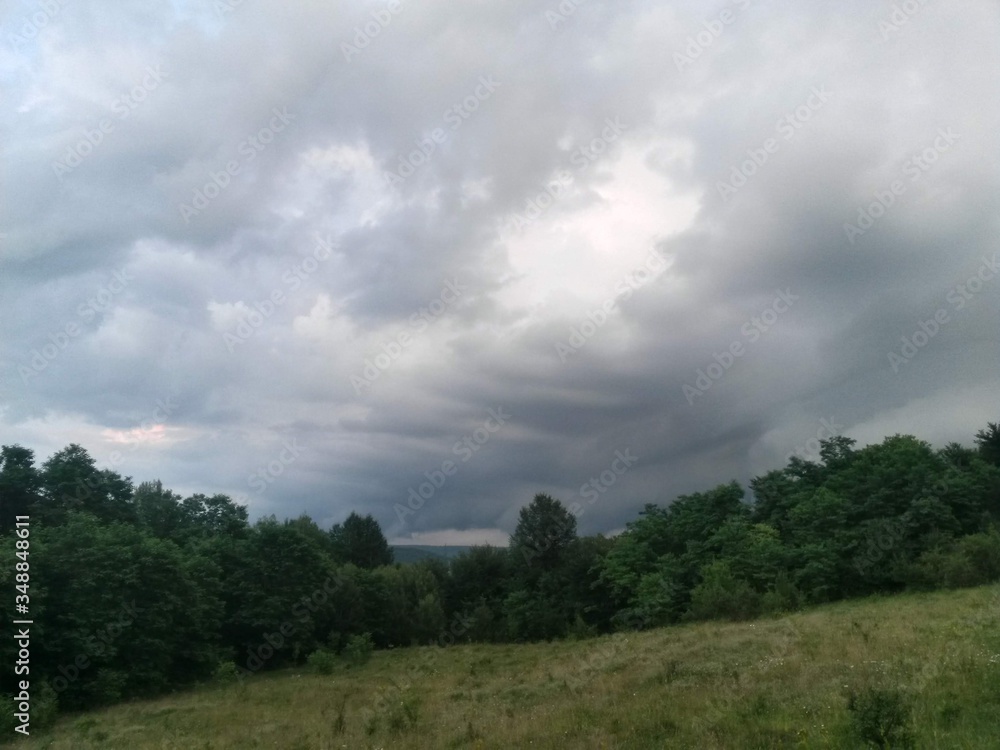 stormy clouds over green forest in summer season
