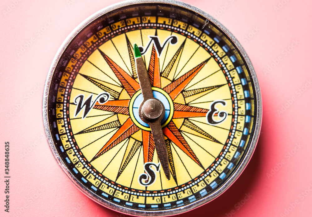 Travel content with old compass. Macro shot on colorful background