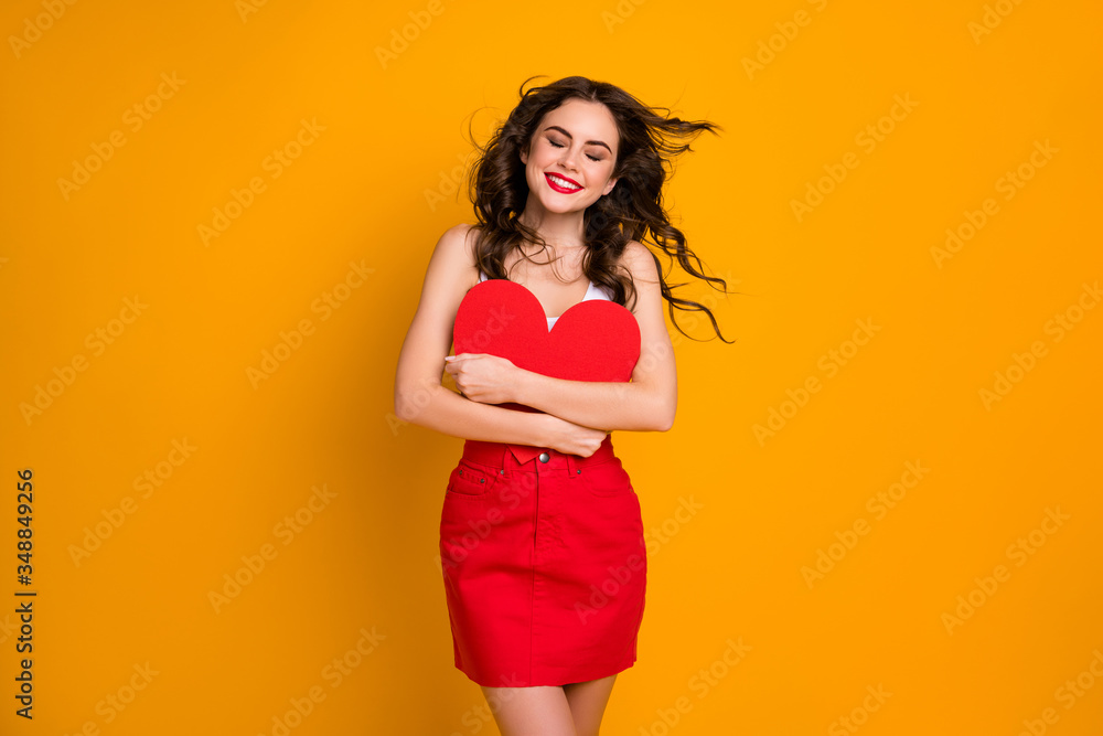 Photo of pretty sincere lady hairstyle flight overjoyed hold big paper heart postcard close to chest eyes closed wear white casual tank-top red mini skirt isolated yellow color background Photo of pretty sincere lady hairstyle flight overjoyed hold big paper heart postcard close to chest eyes closed wear white casual tank-top red mini skirt isolated yellow color background