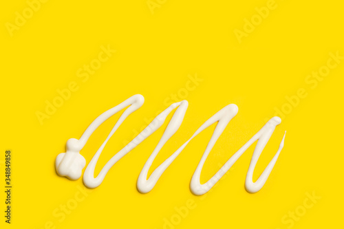 Crema para el cuerpo sobre un fondo amarillo liso asilado y brillante. Vista superio. Copy space © Mercedes Fittipaldi