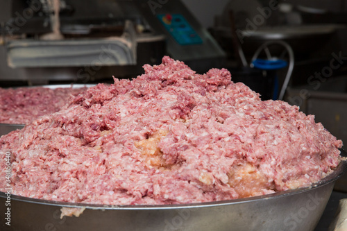 Ground pork in a stainless steel tank to be used as meatballs.