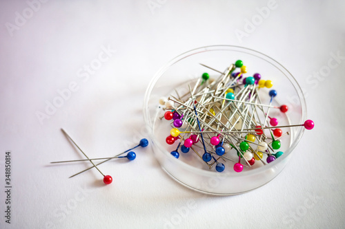 colorful pins in the form of sewing needles on a white isolated background close up