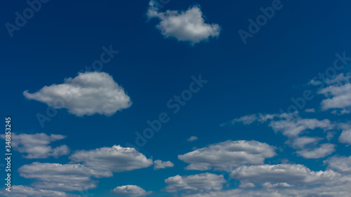 White clouds on a blue sky, background. © Oleksii Skrekoten