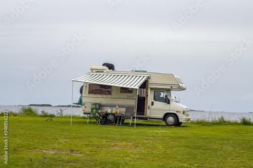 Mobile home on a grassy sea coast on a grey rainy summer day photo