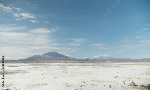 Dry, barren landscape mountain background. Dramatic desert, snowcapped mountains wilderness. Mountain range view. Salt Flats of Uyuni, Bolivia. Copy space, blue sky, nature, hiking, and sand dust