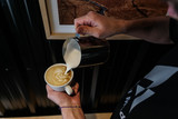Professional barista preparing coffee with patterns on top in a cafe shop. Photo from above. 