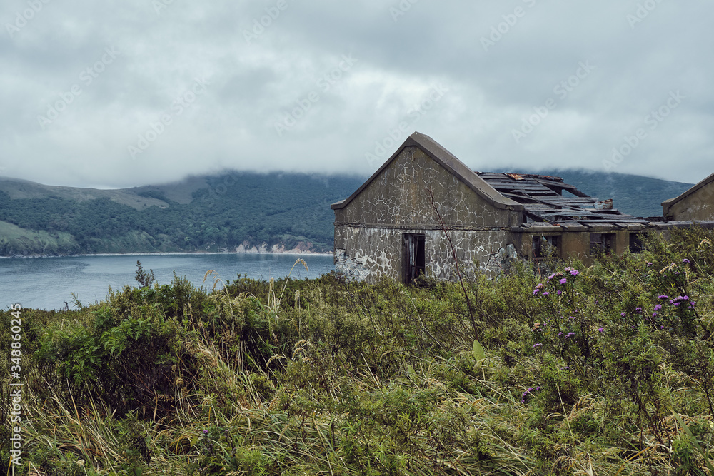 Abandoned building on top of a remote island overlooking the bay on a foggy day. Wildlife and outdoor concept. Nature without people Abandoned building on top of a remote island overlooking the bay on a foggy day. Wildlife and outdoor concept. Nature without people